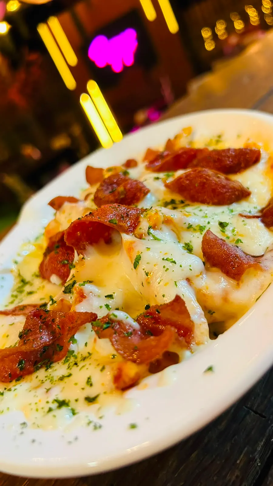 Papas gratinadas con queso cremoso y crujiente tocineta.