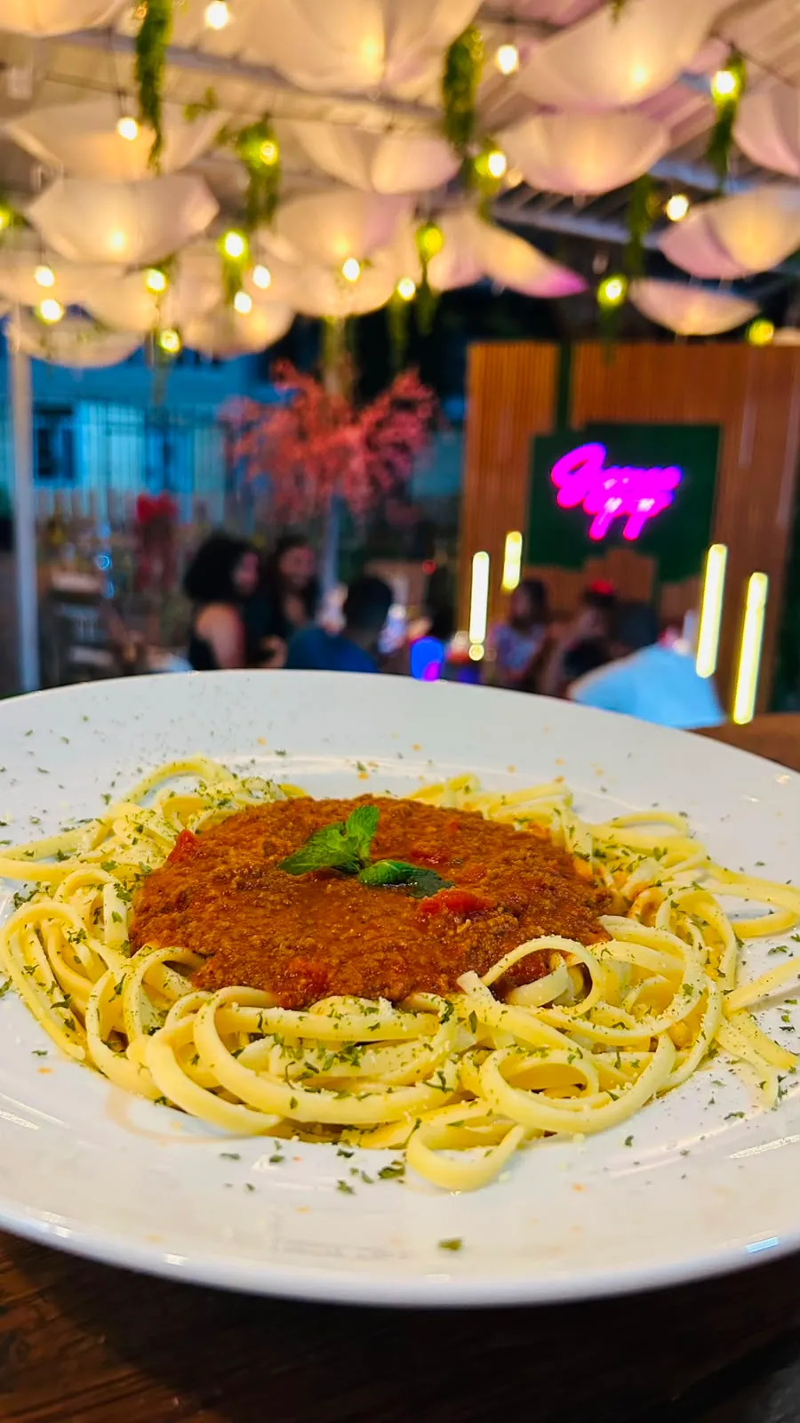 Plato de pasta a la boloñesa con salsa de carne y hierba fresca.