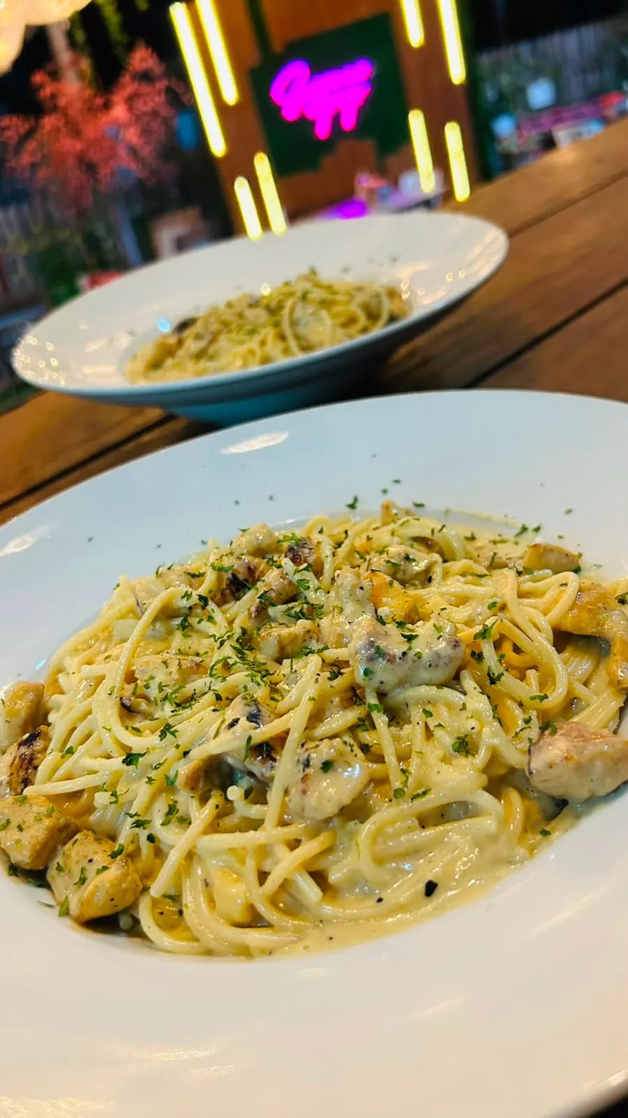 Plato de pasta en salsa blanca cremosa con trozos de pollo a la parrilla.